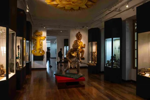 Museum interior with several glass galleries containing various pieces that appear to be pre-Columbian, judging by the large decorative objects surrounding them, such as indigenous figures.