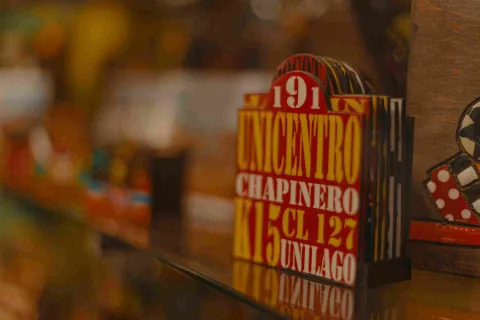 Carteles de transporte de servicio público con letras de color blanco y amarillo en fondo rojo. Se destaca una leyenda que dice: "Unicentro". 