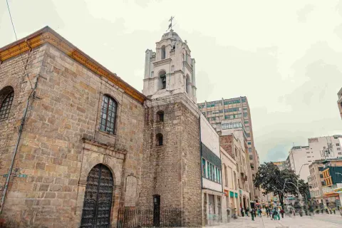  Fachada de la iglesia vista de lado. Al fondo en la calle se observan algunas personas.
