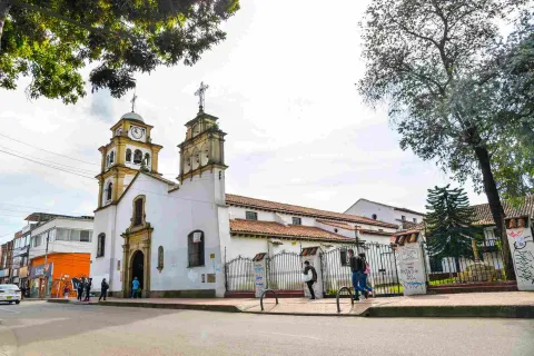Plano de la iglesia vista desde un lado, en la que sobresalen sus dos torres y varias personas al frente.