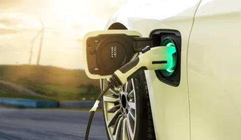 Primer plano de dispensador de electrolinera que carga un automóvil.