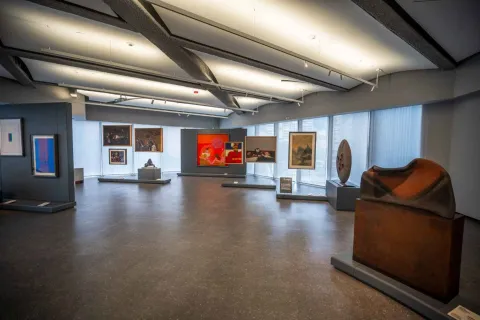 An art gallery with various works displayed on the walls and pedestals.