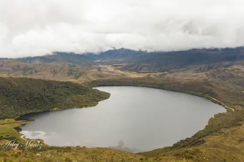 Gran laguna gris en medio de montañas.