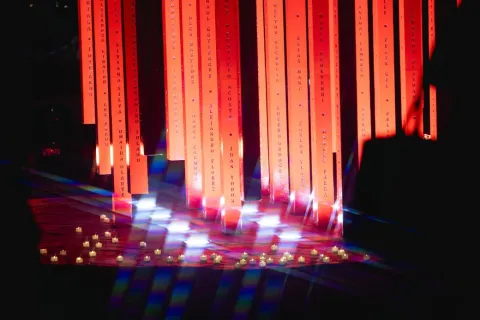 Una luz roja brilla en un escenario iluminado por varias luces.