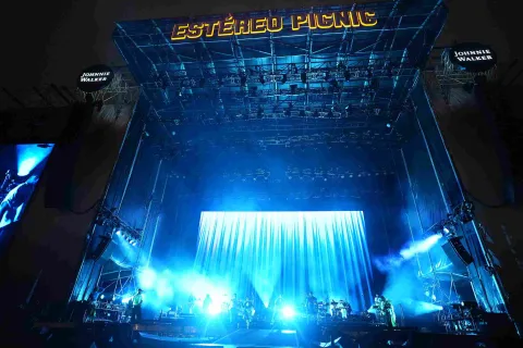 Escenario principal de Estéreo Picnic iluminado en azul, con banda en vivo y gran pantalla de fondo.