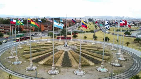 Vista aérea del Monumento a las Banderas con múltiples banderas alrededor de una rotonda en la ciudad.