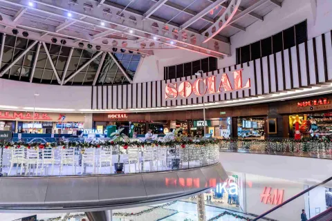 Interior del centro comercial Parque La Colina en Bogotá, con locales comerciales, iluminación moderna y espacios decorados para la temporada navideña.