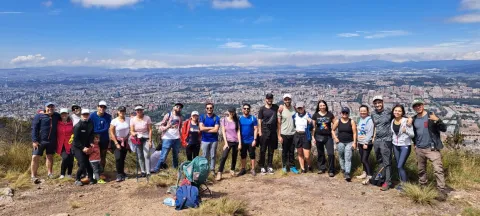  Grupo de personas posa en un mirador natural con vista panorámica de Bogotá y las montañas al fondo.