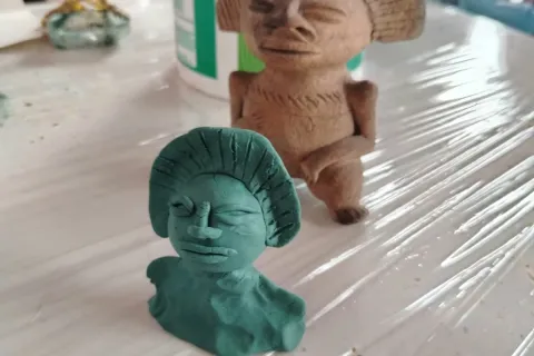  Escultura de arcilla que representa a una mujer y un hombre en una pose íntima y expresiva.