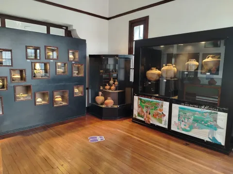  Museo con una variedad de cerámica y pinturas expuestas en un ambiente acogedor y cultural.