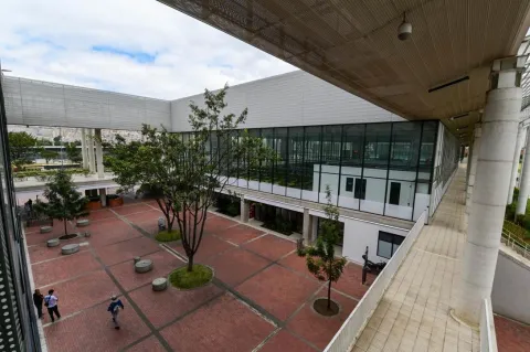 Patio interior del Centro Felicidad (CEFE) El Tunal, un espacio abierto que integra arquitectura moderna, amplias zonas de circulación y áreas verdes. La imagen resalta los árboles, los senderos peatonales y las fachadas acristaladas que favorecen la iluminación natural y la conexión entre los diferentes espacios del complejo.