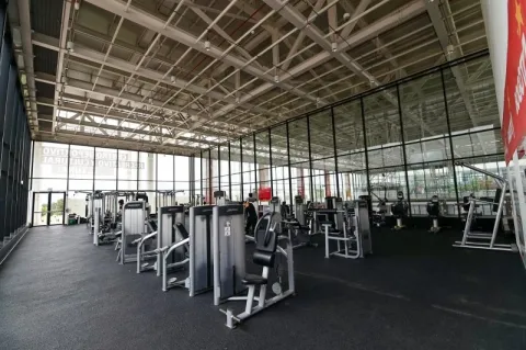  Interior del gimnasio del Centro Felicidad (CEFE) El Tunal, equipado con modernas máquinas de entrenamiento y amplios espacios para la actividad física. La iluminación natural, las fachadas en vidrio y el diseño abierto crean un ambiente cómodo y funcional para el ejercicio y el bienestar de los visitantes.
