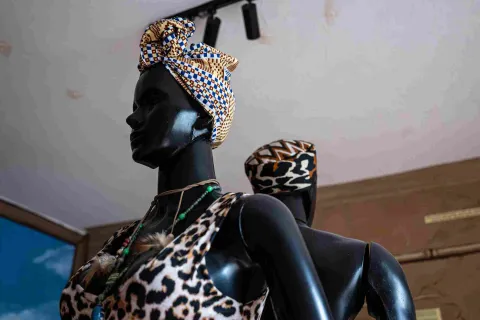 Mannequins display clothing and accessories inspired by Afro-Colombian fashion, featuring turbans, prints, and traditional necklaces in a cultural exhibit.