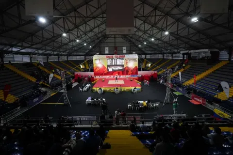 General view of the Palacio de los Deportes in Bogotá during an international weightlifting competition, showing the central platform, stands, and spectators.