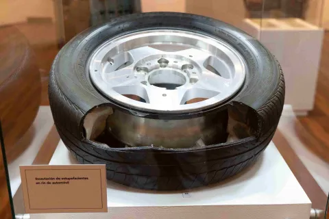  Llanta de automóvil modificada con compartimentos ocultos, exhibida como evidencia de incautación de estupefacientes en un espacio museográfico.