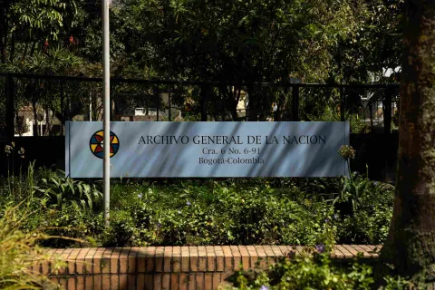 Letrero del Archivo General de la Nación en Bogotá, rodeado de jardines y vegetación.
