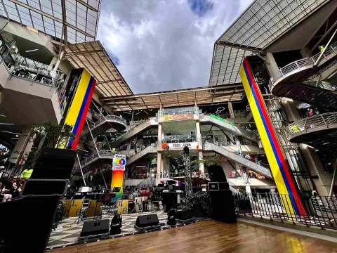 El amplio espacio central de Portal 80 combina arquitectura, comercio y entretenimiento en un ambiente dinámico. Sus escaleras, pasillos y grandes estructuras decoradas con los colores de Colombia crean un escenario ideal para eventos y actividades especiales.