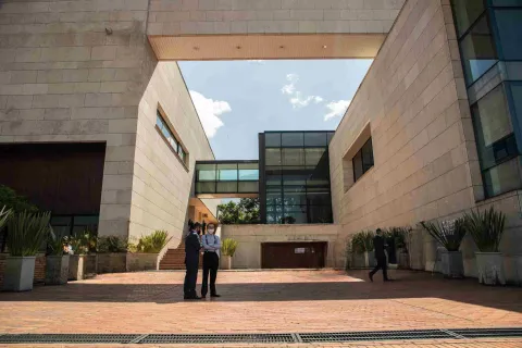 Patio interior del Archivo de Bogotá, rodeado por modernas estructuras de piedra y vidrio, con visitantes en el lugar.