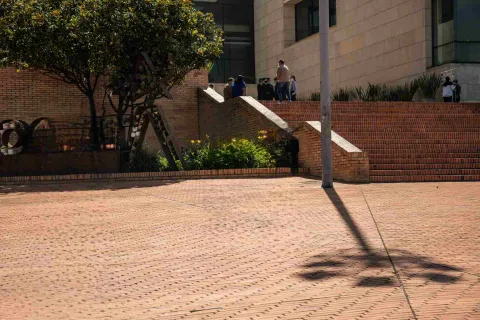 Escalinatas de ladrillo y jardines en el exterior del Archivo de Bogotá, con visitantes en la entrada del edificio.