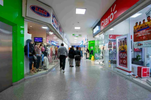 Pasillo comercial del Centro Comercial Galerías, con una amplia variedad de tiendas y visitantes recorriendo sus espacios.