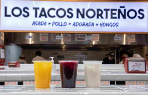  Tres bebidas de colores acompañadas por la barra de Los Tacos Norteños.