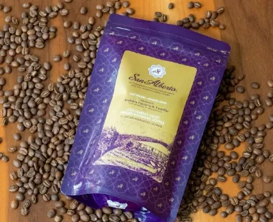 Empaque de café San Alberto rodeado de granos de café, destacando la identidad y tradición de este café colombiano de especialidad.