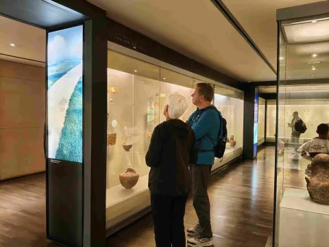 Visitantes recorren las salas del Museo del Oro y observan piezas arqueológicas exhibidas en vitrinas iluminadas.