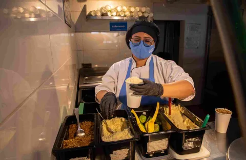  Cocinera prepara esquites con maíz y diferentes ingredientes en la estación de servicio.
