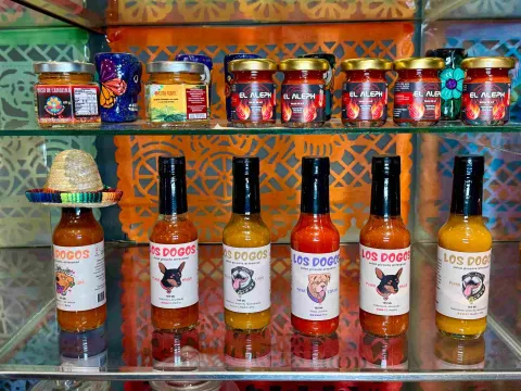 Selección de salsas picantes artesanales y productos de sabores intensos exhibidos en una vitrina.