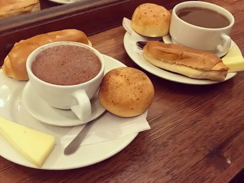 Chocolate caliente acompañado de queso, almojábana y envuelto tradicional.