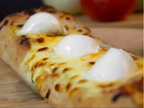 Pizza de masa madre cubierta con queso fundido y bocados de mozzarella.