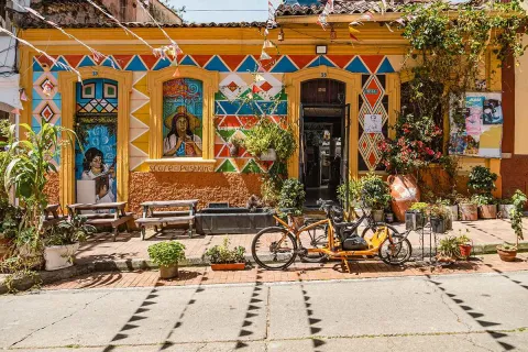 Casa tradicional de La Candelaria, con coloridas fachadas, murales, plantas y bicicletas en la calle.
