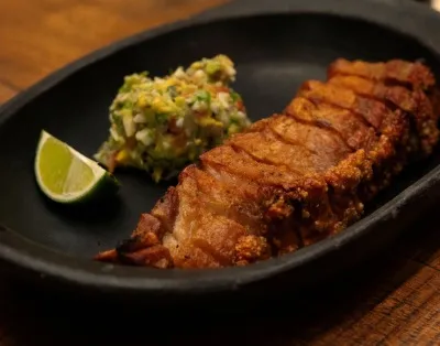 Costillas doradas y crujientes, acompañadas de una fresca preparación de aguacate y un toque de limón.