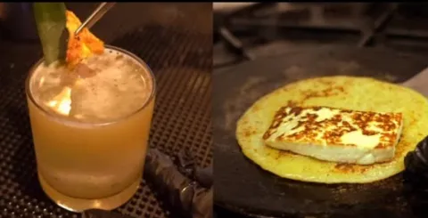  Bebida cítrica y refrescante junto a una arepa dorada con queso, una combinación que celebra los sabores colombianos.