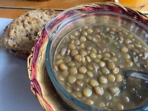 Sopa de lentejas acompañada de pan artesanal.