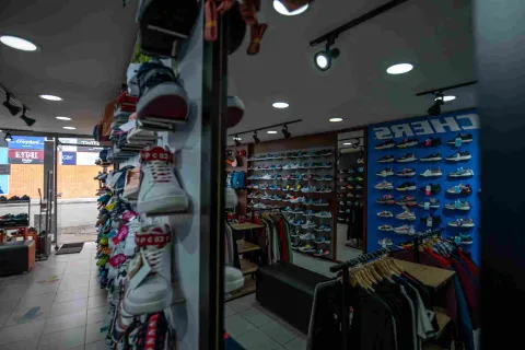 Interior de una tienda deportiva en Floresta Outlet, con una amplia exhibición de zapatillas de diferentes estilos y colores, además de prendas y accesorios organizados en estanterías y exhibidores.