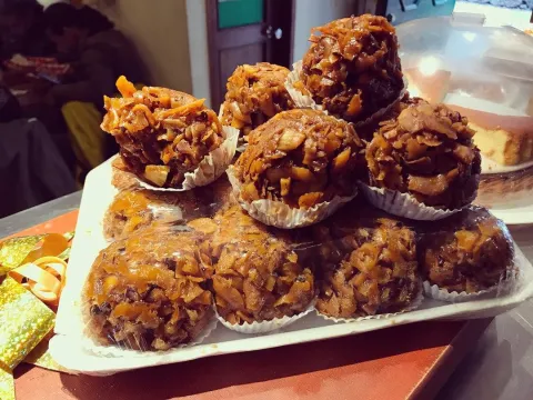 Dulces tradicionales de coco, dorados y caramelizados, exhibidos en una bandeja.