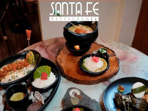 Variedad de platos de la cocina de Santa Fe Restaurante, presentados con coloridos ingredientes, acompañamientos y detalles de inspiración colombiana.