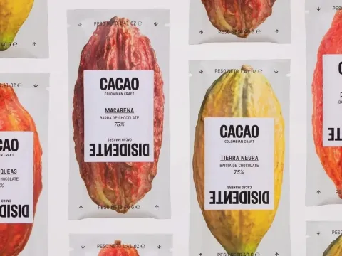 Productos de cacao colombiano presentados en empaques con forma de mazorca y diferentes porcentajes de chocolate.