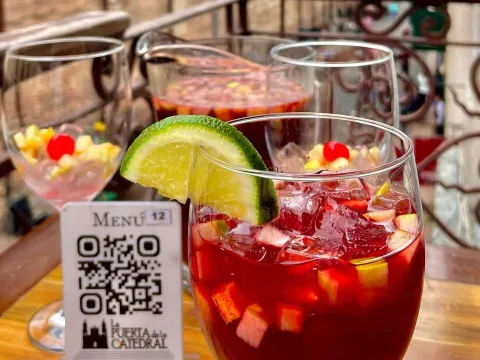Vasos de sangría con frutas y limón, servidos en una mesa de La Puerta de la Catedral.