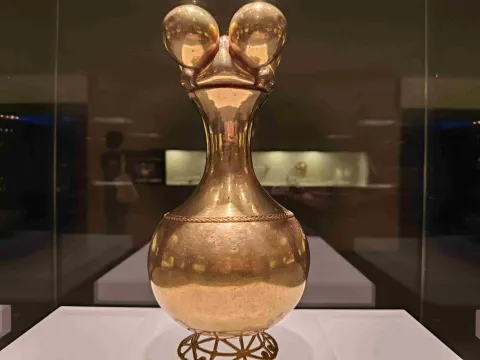 Pieza de orfebrería precolombina en oro, exhibida en una vitrina del Museo del Oro de Bogotá y destacada por su detallado diseño.