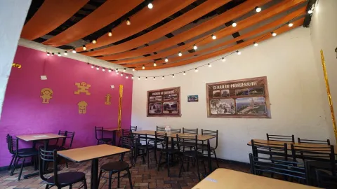  Área del comedor con decoración cultural local, iluminación de guirnaldas y tela en el techo.