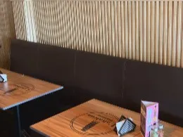 Ambiente de L’altalena Pizzería, con mesas de madera y decoración cálida.