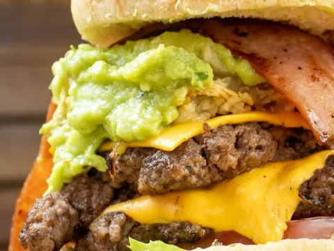 Hamburguesa con doble carne, queso, tocineta y guacamole, preparada al estilo de Good Burger.