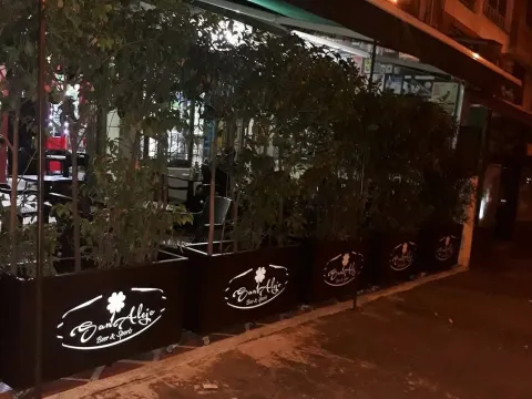 Terraza exterior de Sanalejo Beer & Sports, rodeada de vegetación y con ambiente nocturno.
