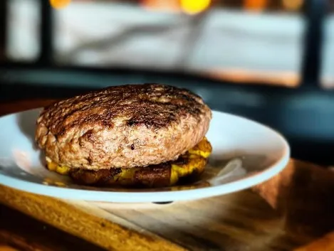 Medallón de carne de res preparado a la parrilla y servido sobre una base de acompañamientos