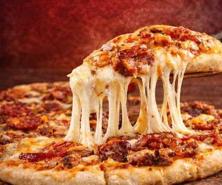  Pizza con queso derretido y trozos de carne, servida recién horneada.