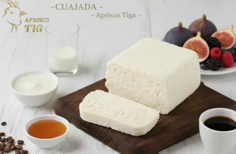 Cuajada de leche de cabra acompañada de frutas, miel y bebidas, como muestra de la producción artesanal del Aprisco Tiga.