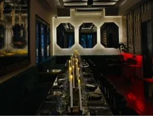 Comedor elegante y sofisticado, con mesas dispuestas para grupos, iluminación tenue y detalles decorativos contemporáneos.