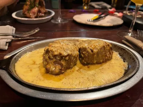 Medallones de cordero bañados en una cremosa salsa, servidos en un plato de presentación.